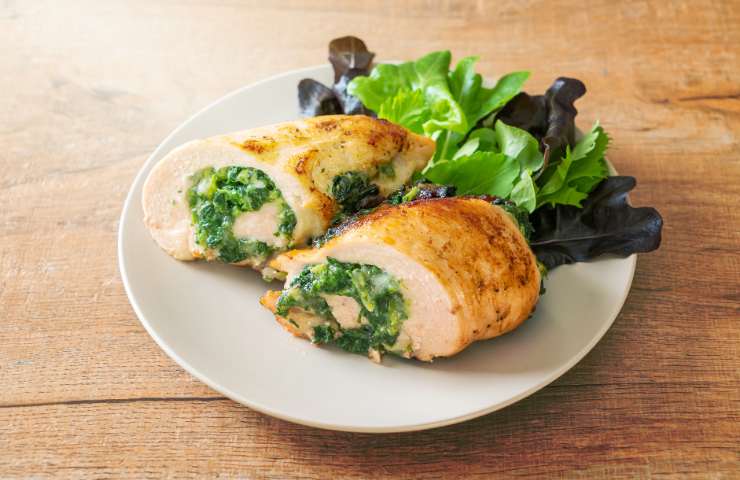 Un piatto di pollo e verdure a foglia verde