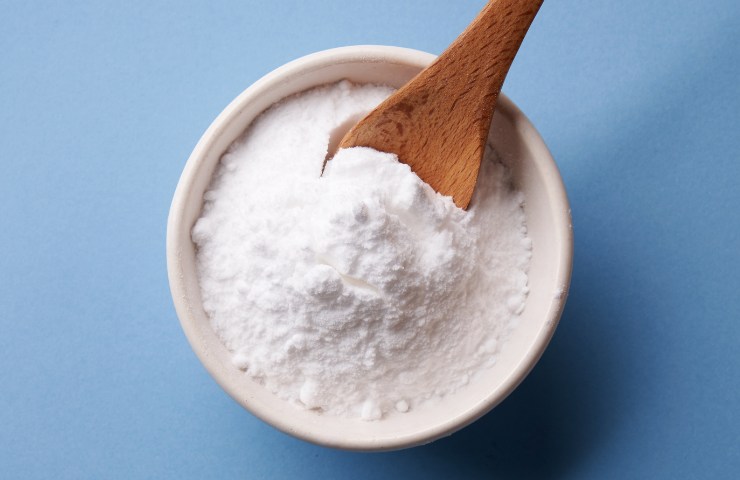 Una tazza riempita con del bicarbonato di sodio