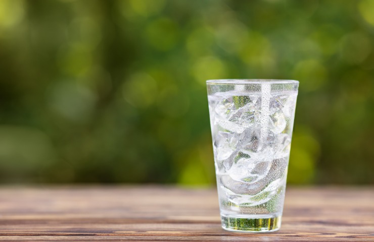 Un bicchiere di acqua fredda con ghiaccio