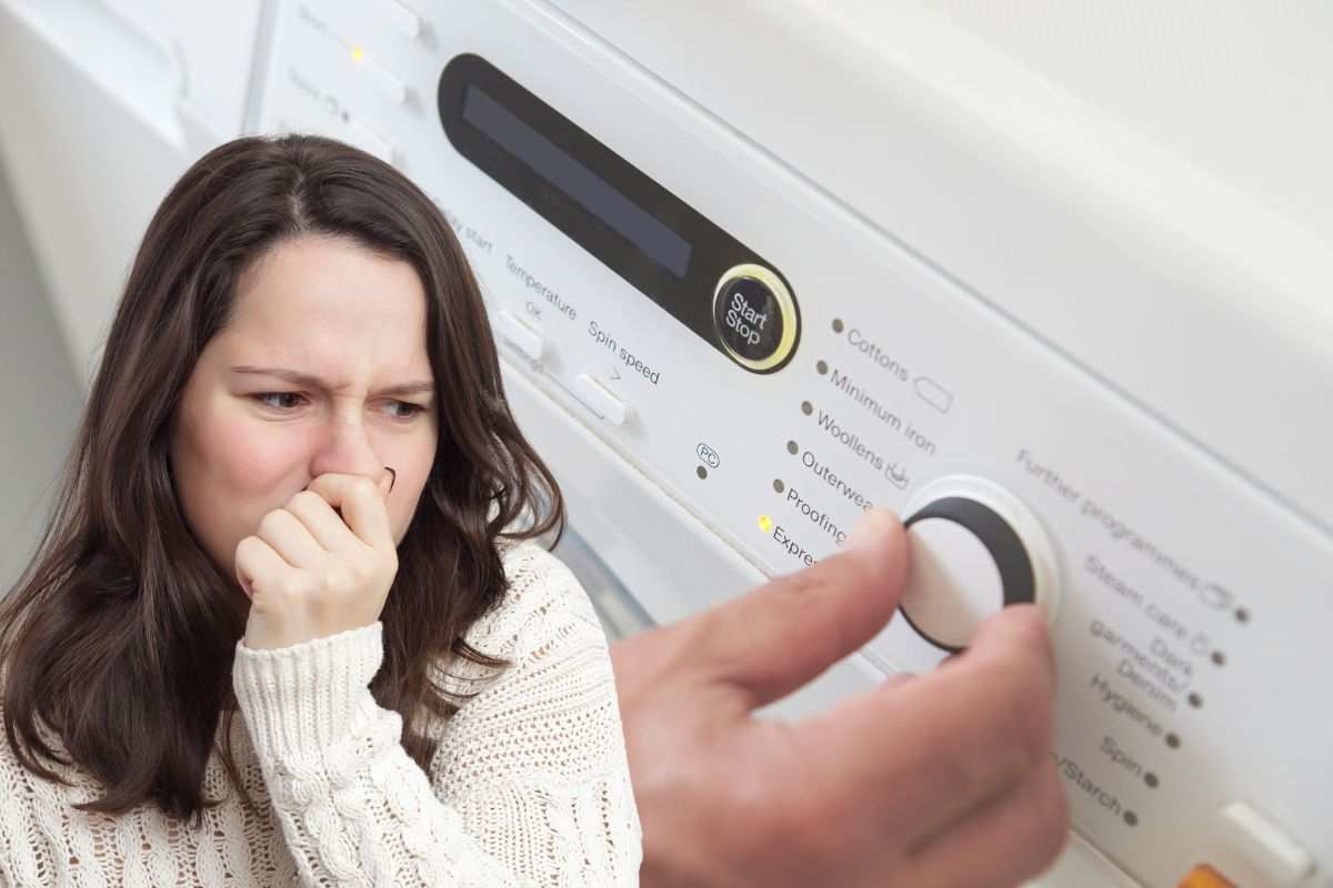 lavatrice e ragazza si tappa il naso