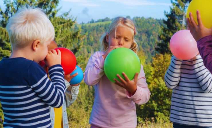bambini gonfiano palloncini