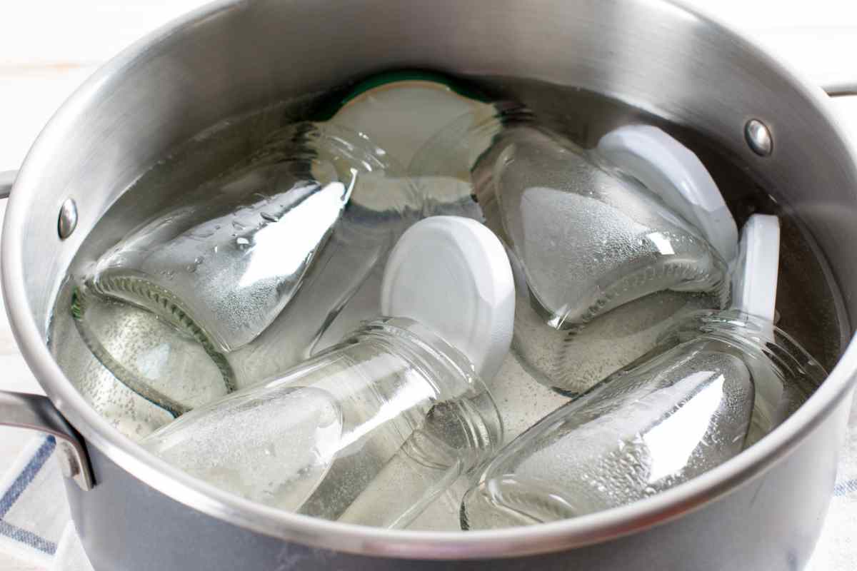 Pentola con acqua e barattoli di vetro