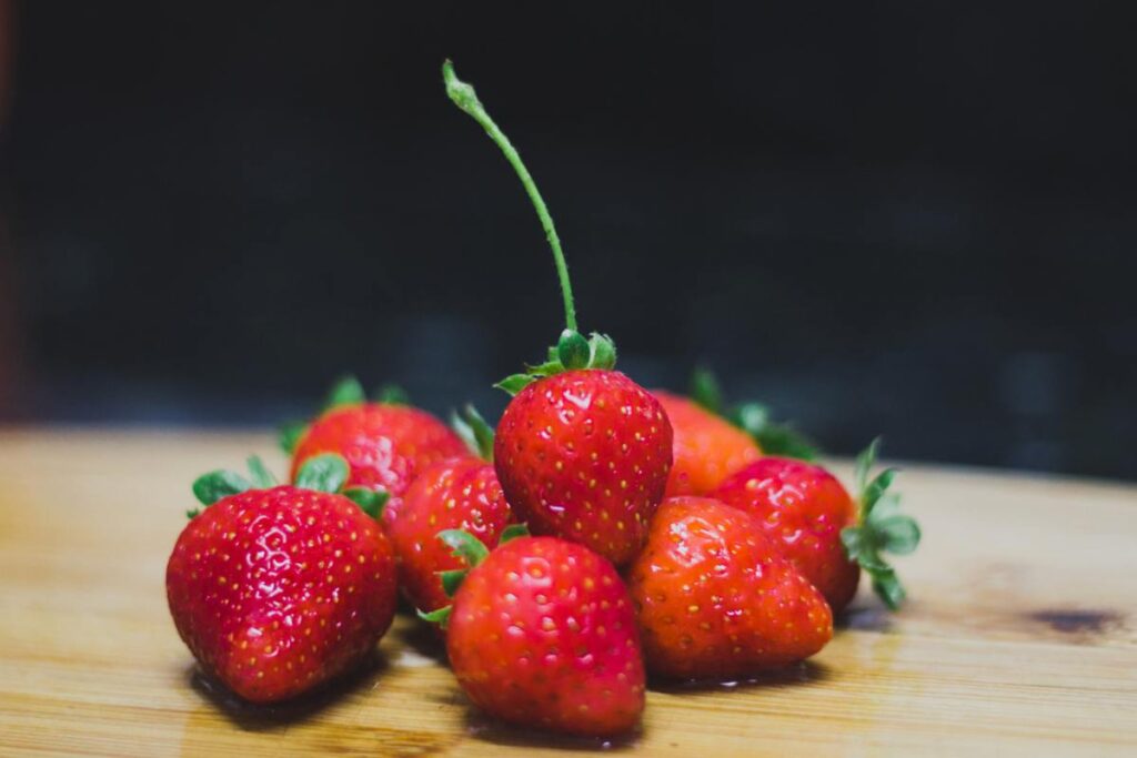 Fragole sparse su piano in legno
