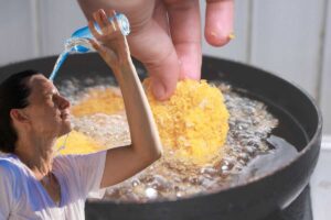 pentola dove frigge il cibo e ragazza che si bagna la testa