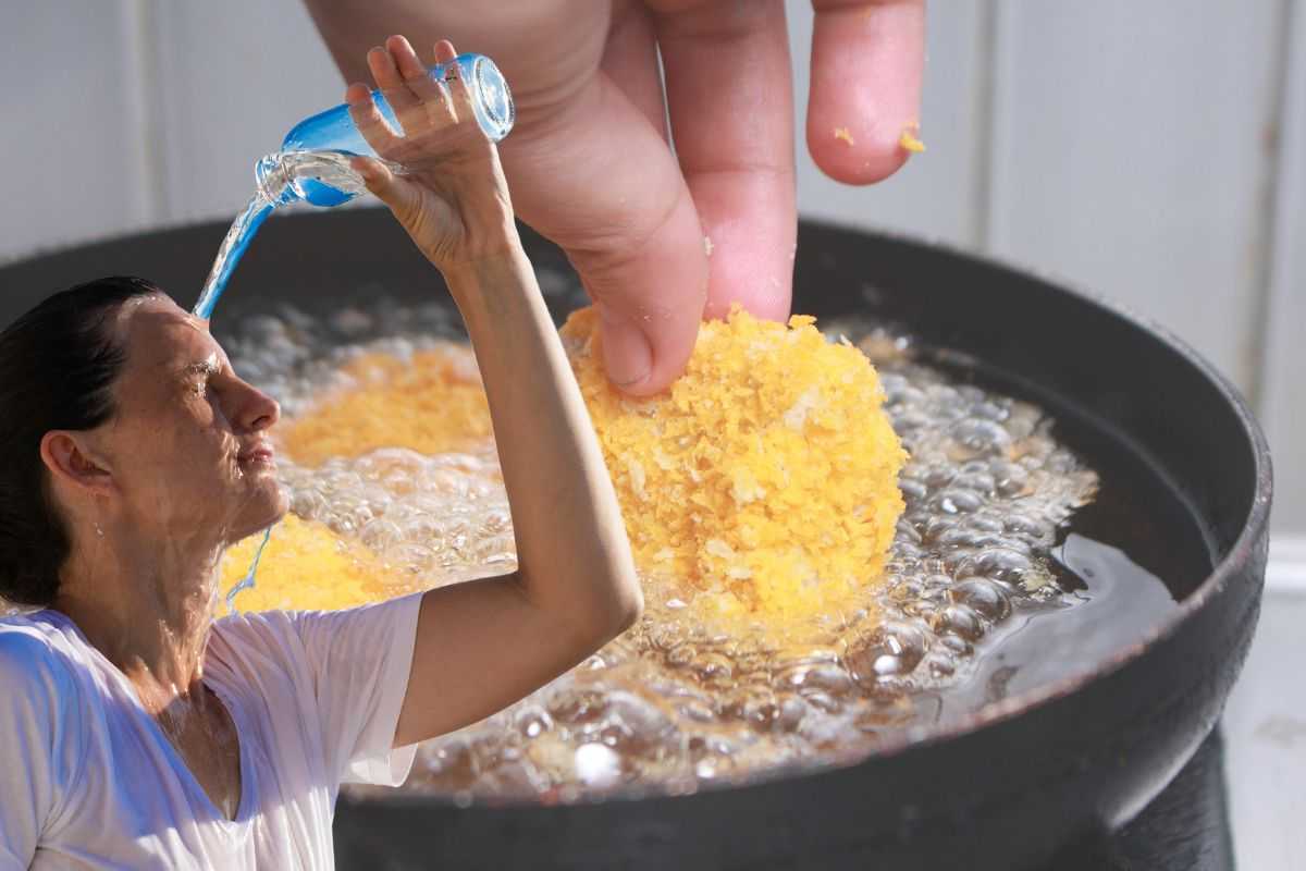 pentola dove frigge il cibo e ragazza che si bagna la testa