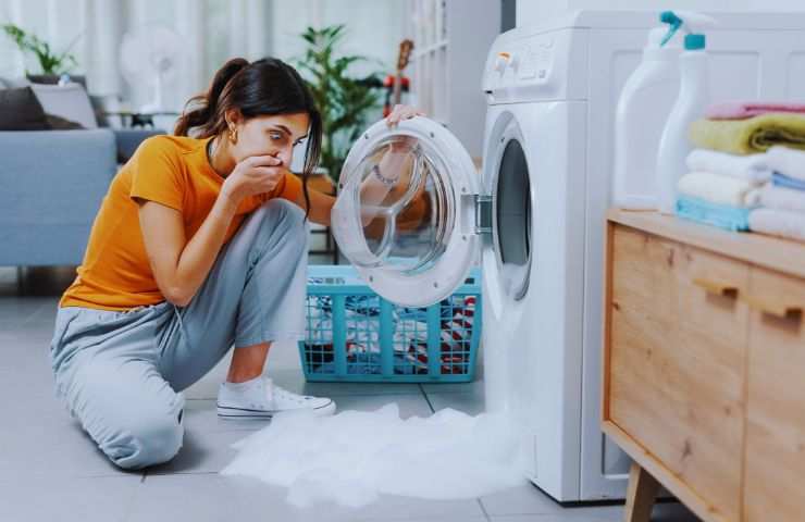 ragazza panico davanti alla lavatrice