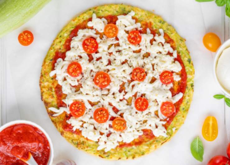 pizza di zucchine con sopra pomodorini passata di pomodoro e formaggio