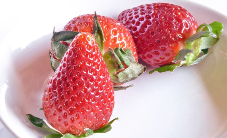 Tre fragole in un piatto
