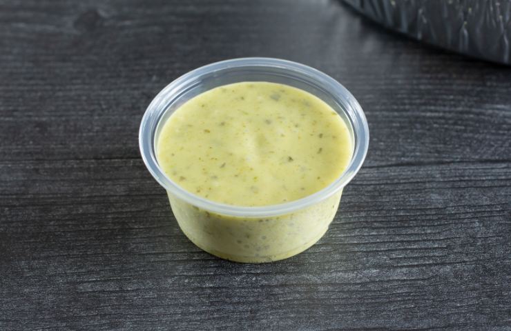 Della salsa di avocado in una vaschetta di plastica