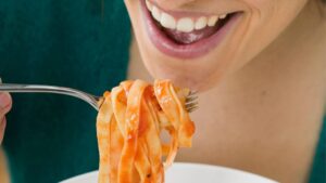 Una donna che mangia delle tagliatelle