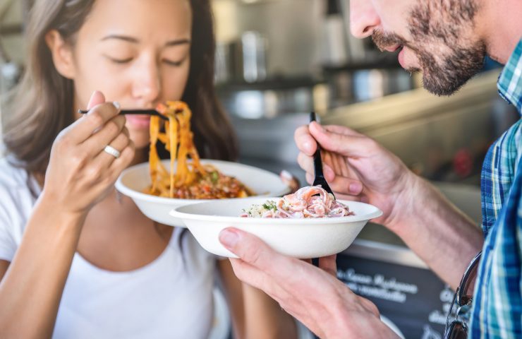 Due persone che mangiano della pasta