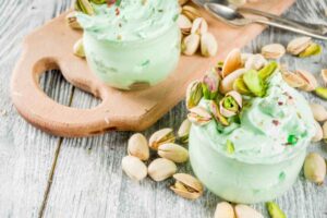 due coppette di gelato al pistacchio con sopra dei pistacchi
